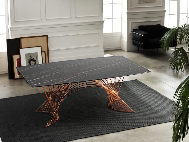 modern black table with copper patterned legs in white room
