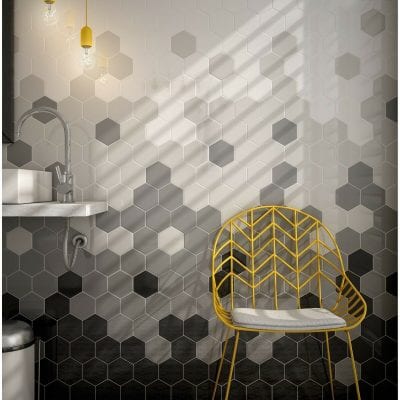 bathroom with hexagon tiles in black, white and grey, with yellow chair
