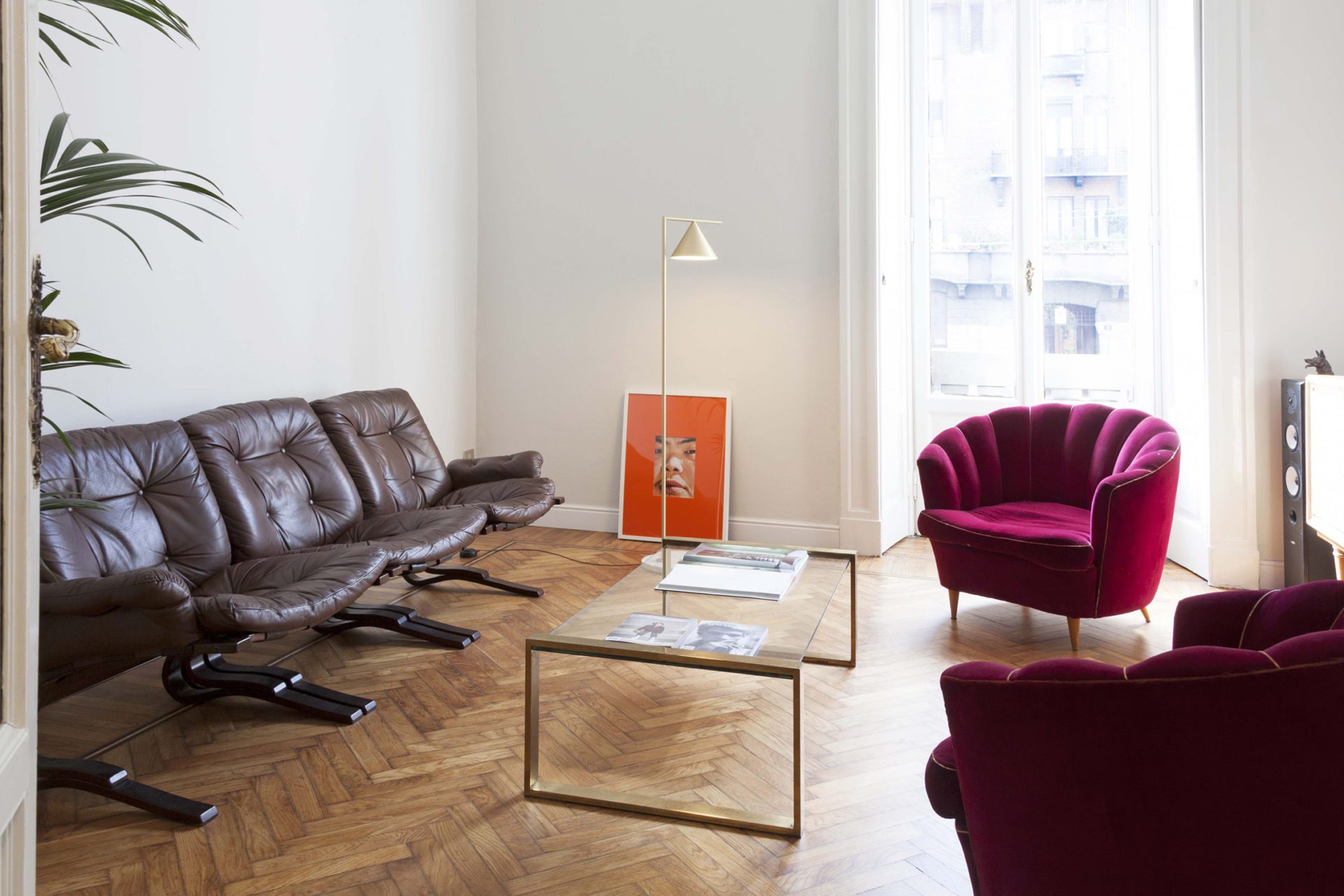 Seating area with leather sofa and fushia armchair